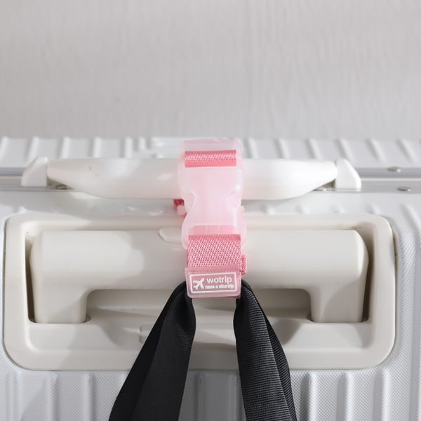 "Säädettävä matkatavarahihna kirkkaissa väreissä, kiinnitetty mustaan matkalaukkuun oranssilla ja keltaisella yksityiskohdall